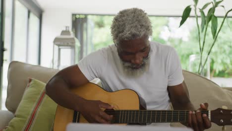 Video-De-Un-Triste-Anciano-Afroamericano-Tocando-La-Guitarra-Y-Usando-Una-Computadora-Portátil