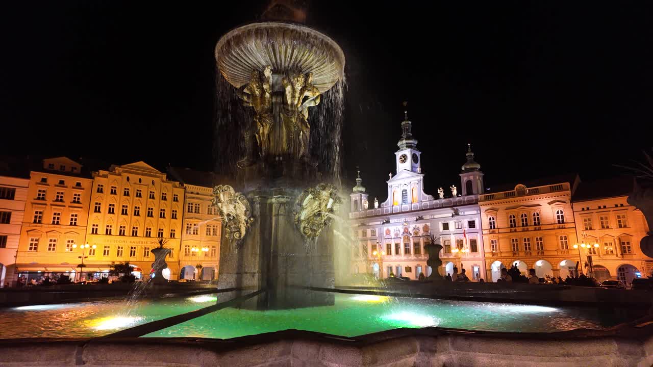 Overview of the historic Prémysla Otakara II Square in Ceske Budejovice, water cascades down fountain illuminated at night