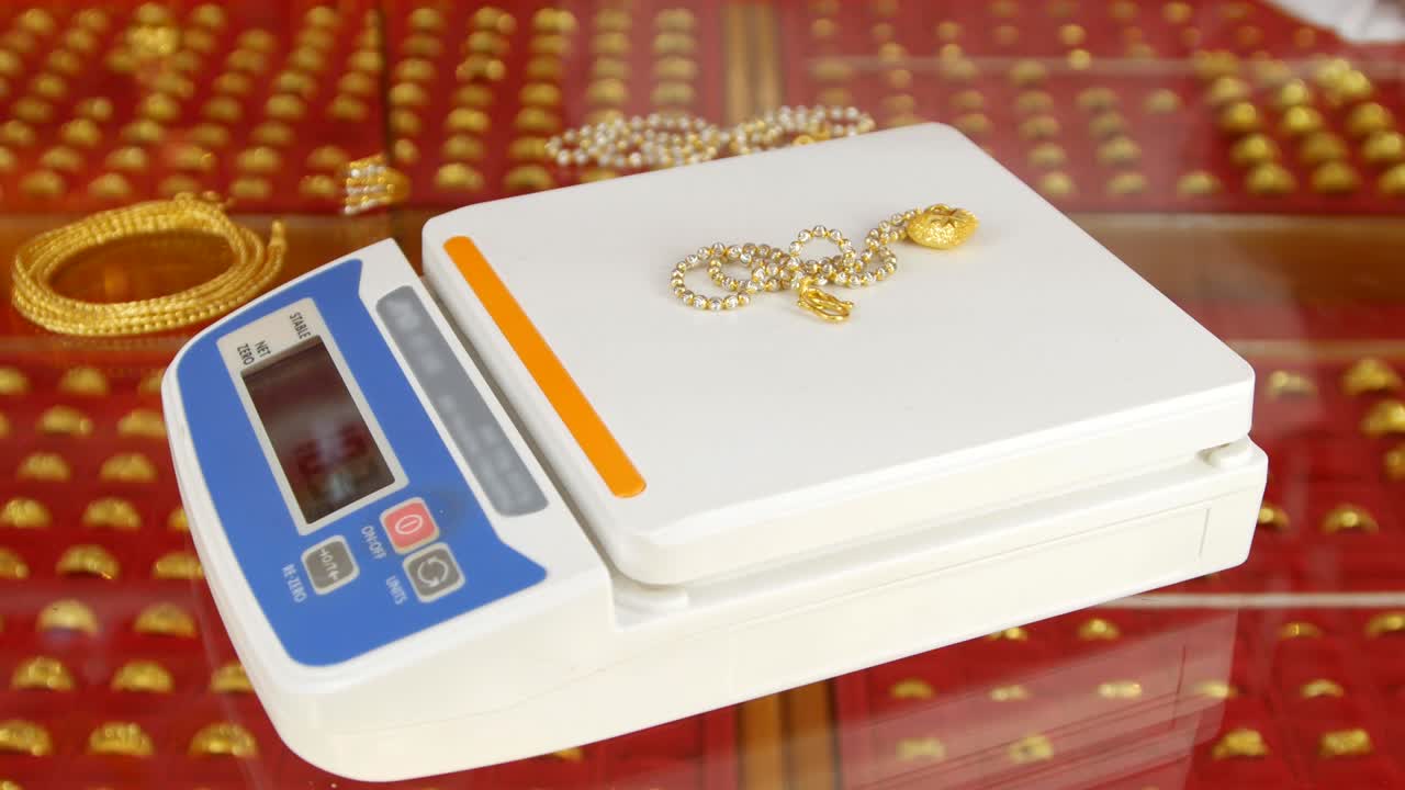 금 반지 및 목걸이를 손으로 매장하는 디지털 무게