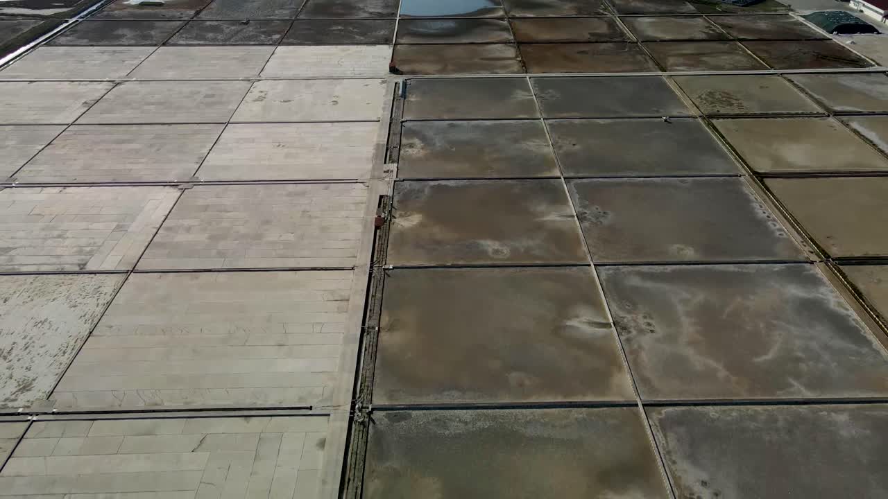 Slow close reverse drone flight next to a salt field in Croatia at daytime