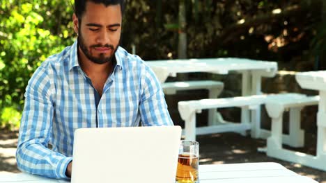 Man-using-laptop-while-having-beer-4k