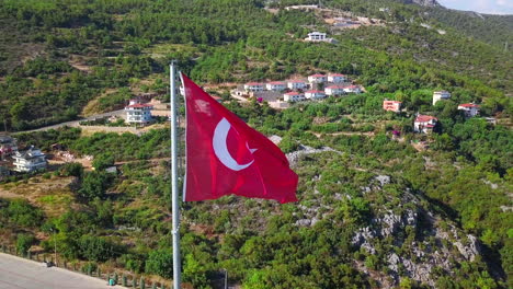 bandera turca volando sobre una comunidad en la ladera de una colina