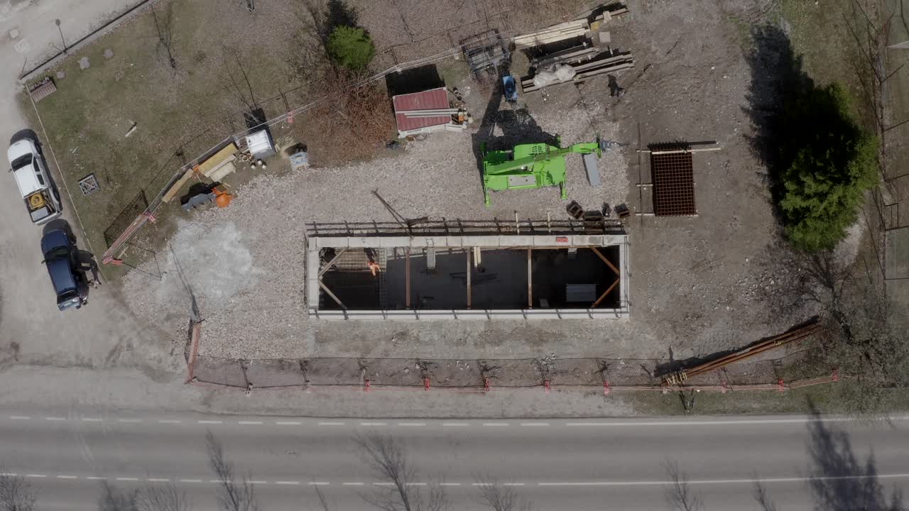 Top down aerial shot of a construction site with a machine in backwards movement.