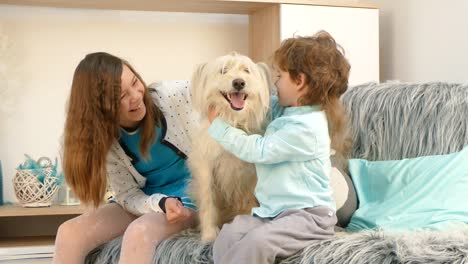 a girl with a boy is stroking a dog