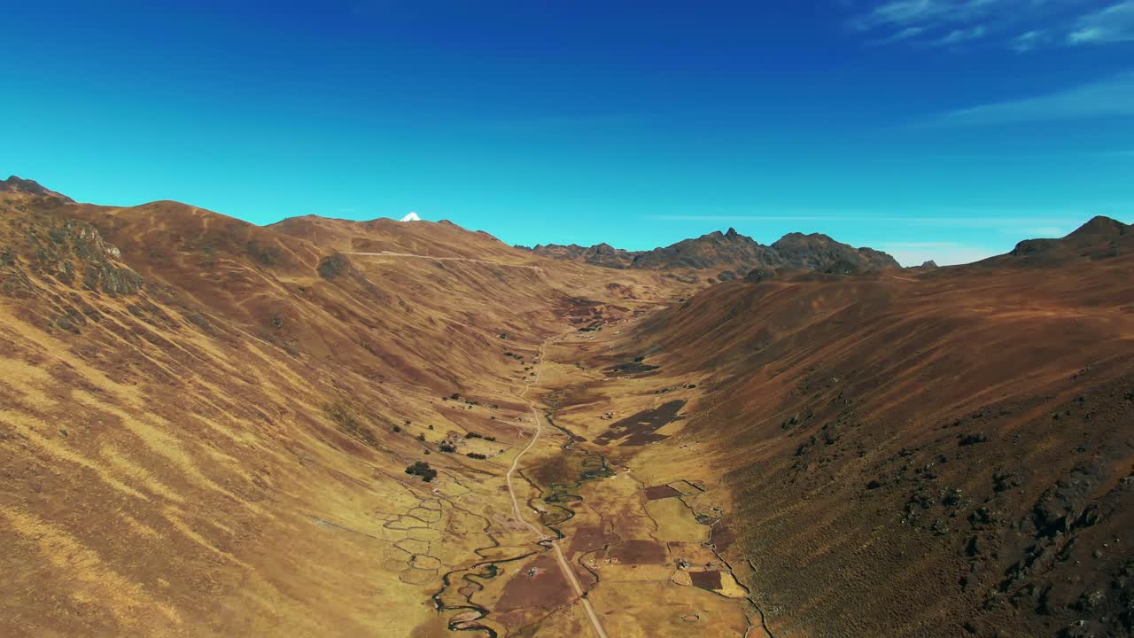 Stunning aerial of Chaullacocha remote valley with river pyramid-shaped snow-covered Nevado Veronica peak. Peruvian highlands near Cusco. Quechua land, indigenous community
