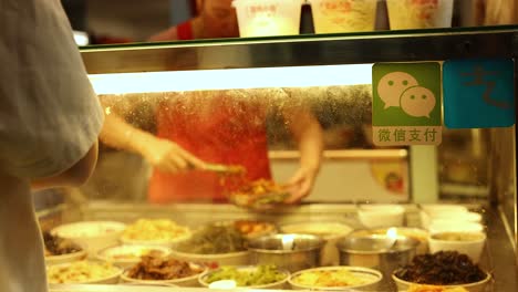 vendor preparing food at a bustling stall