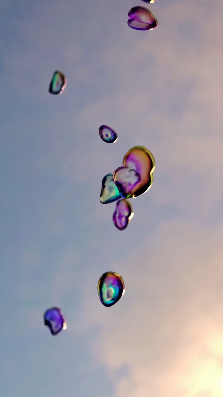 A low-angle video shot captures iridescent bubbles floating against a soft, pastel sky