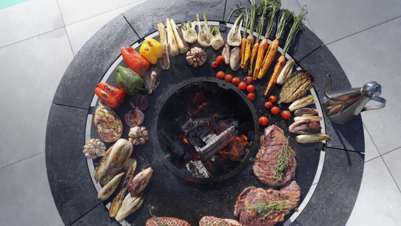 Rising shot of cooked food on an open-top round barbecue ready to be served