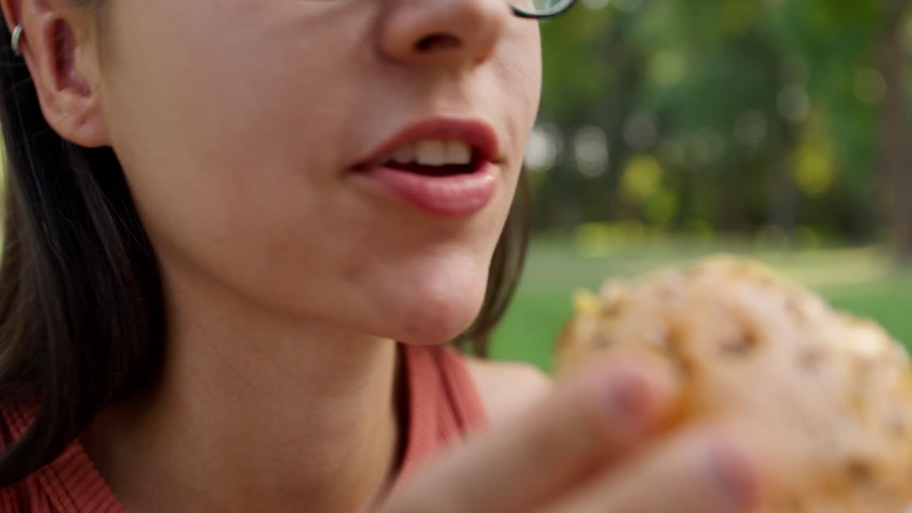 mujer comiendo una hamburguesa en el parque