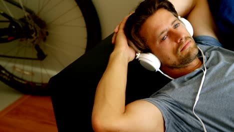 man listening music on headphones living room 4k