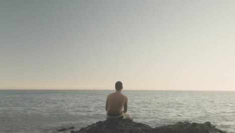 hombre mirando el horizonte en una playa rocosa en españa, gran canaria