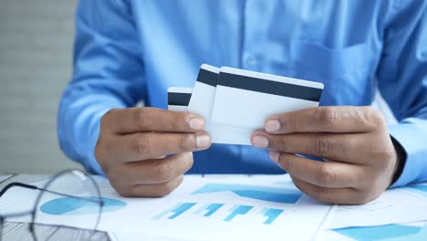 person holding credit cards over financial documents