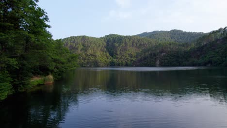 Calm-waters-of-lake-Cambous-in-Branoux-les-Taillades-France,-Aerial-low-angle-shot