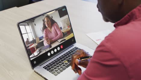 African-american-man-using-laptop-for-video-call,-with-business-colleague-on-screen