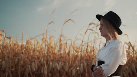 Farmer-in-a-dress-and-hat-walks-in-a-field-of-ripe-corn-8