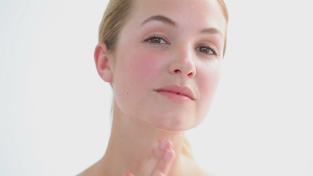 mujer rubia masajeando una de sus mejillas