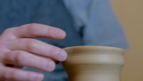 professional potter shaping pot in pottery workshop