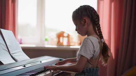 Balanced-kid-musician-plays-piano-looking-at-sheet-music