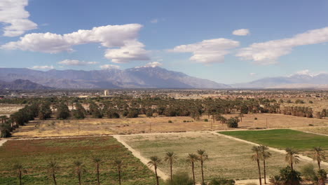 Drone-view-of-Coachella-Valley-California-with-date-palm-trees-and-San-Jacinto-Mountains-in-distance