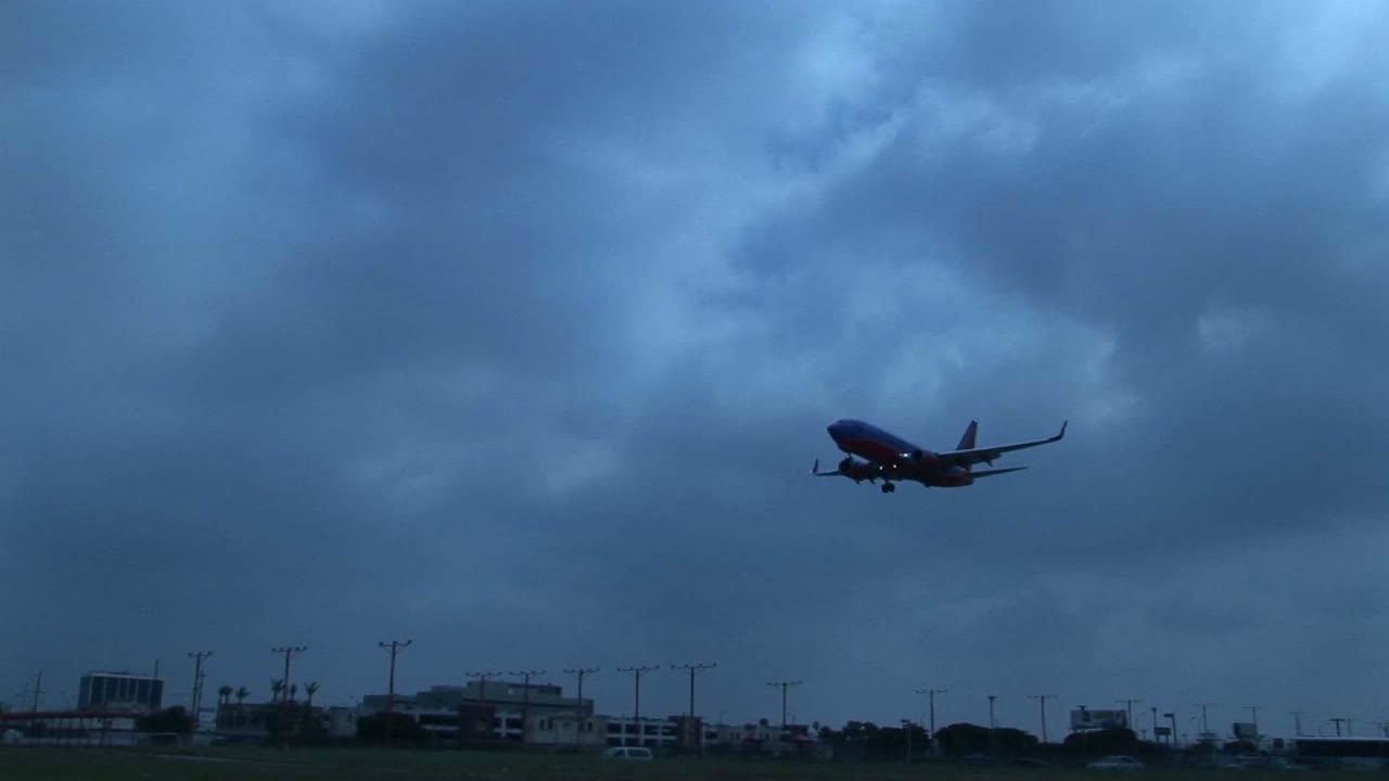 un avión a reacción aterriza en la pista de un aeropuerto contra el cielo oscurecido