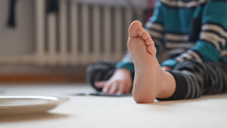 barefoot boy playing on the floor of his room