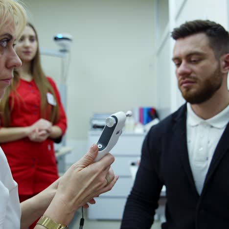 doctor checking eyes with device
