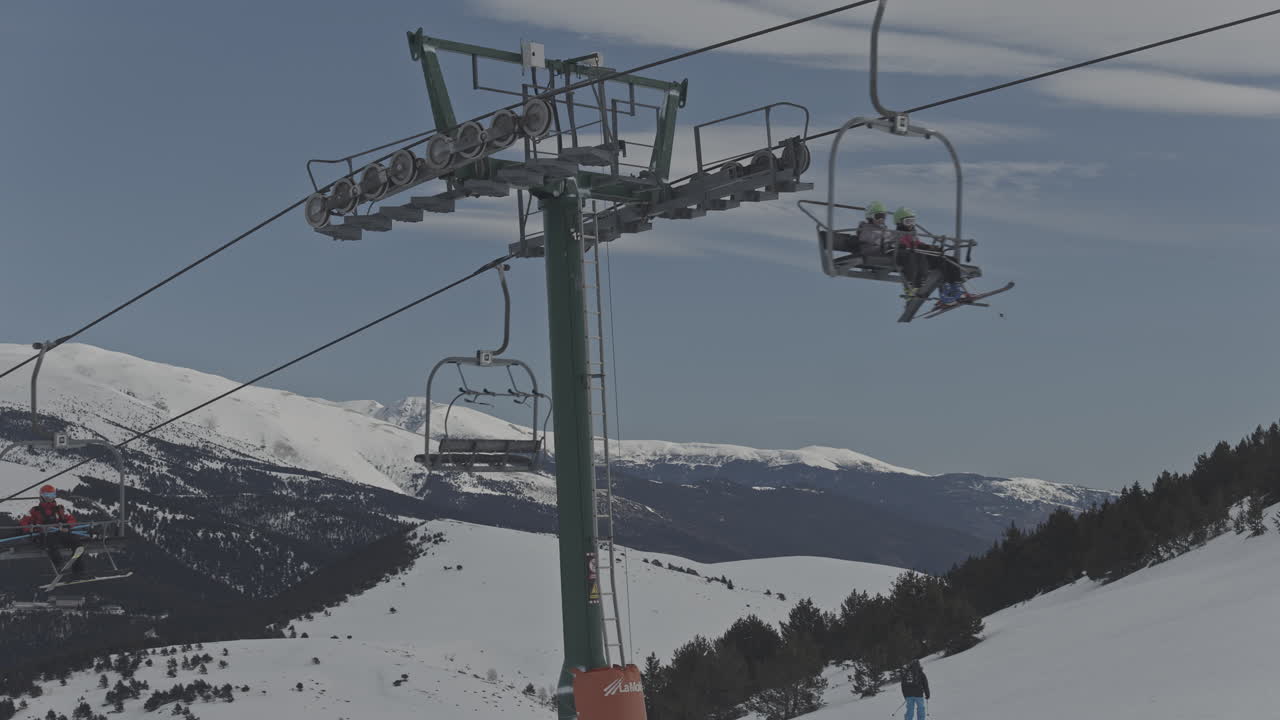 Sciatori e snowboarder su una seggiovia in un paesaggio montano innevato