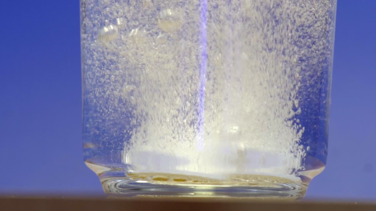 グラスの中で発泡錠が溶けている様子。マクロでのクローズアップ。