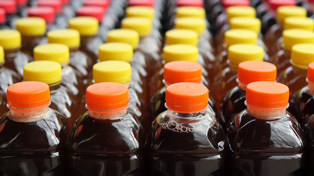 Fileiras de garrafas plásticas de bebidas com tampas coloridas