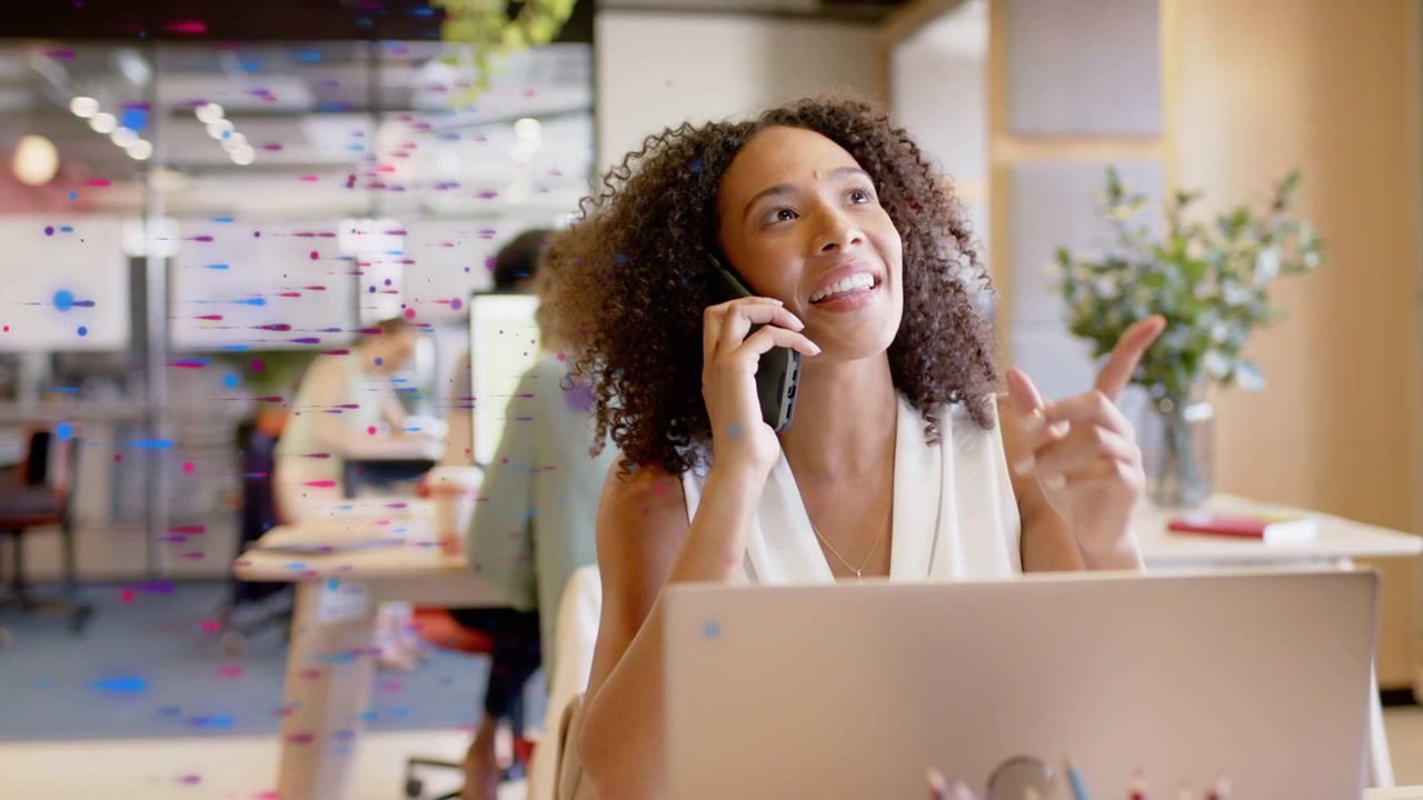 Kantoorvrouw ontvangt telefoongesprek terwijl ze laptop gebruikt tijdens een zakelijk gesprek, luistert, beslist en lacht.