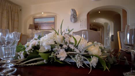 decoración floral de una pieza central para una cena o un evento, decoración basada en rosas blancas y otras flores blancas, mesa preparada para dar la bienvenida a los invitados