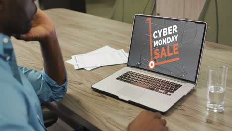 hombre afroamericano en la mesa usando una computadora portátil, compras en línea en cyber monday, cámara lenta