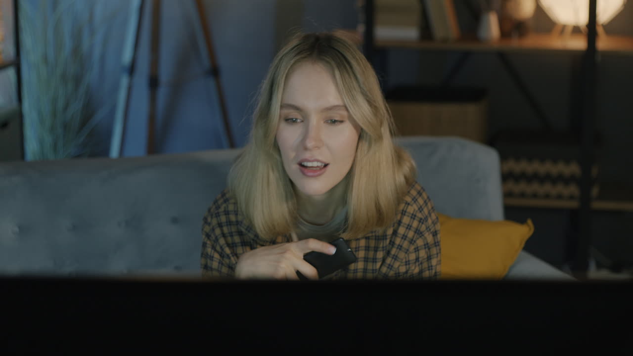 Young Woman Relaxing on Couch Watching TV