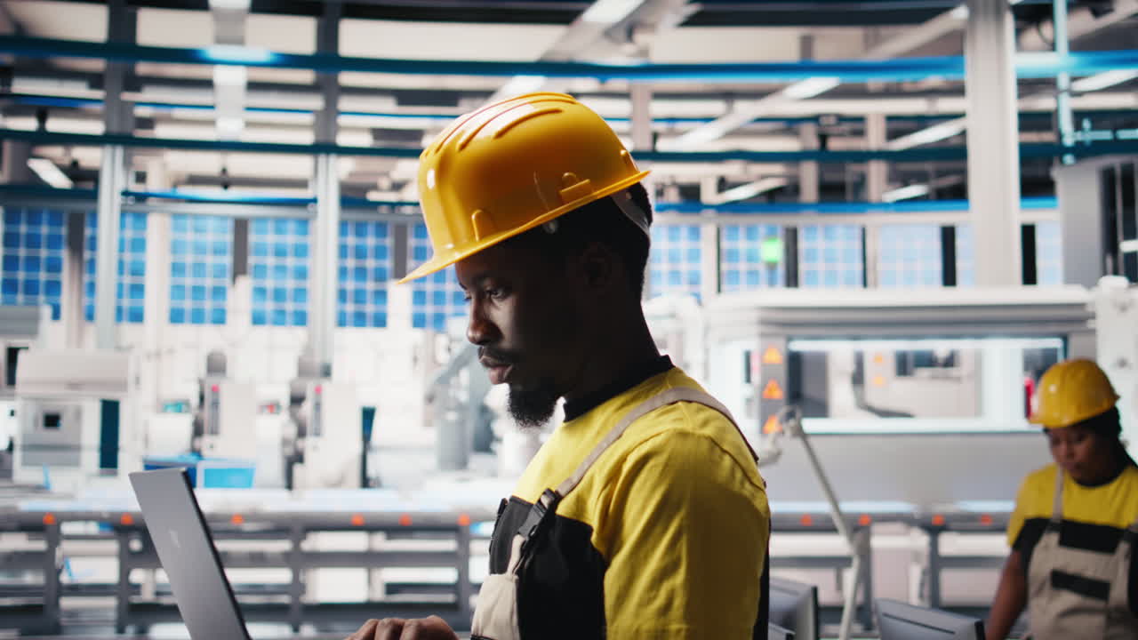 Vertical Video Photovoltaics factory technician optimizing production flow using laptop