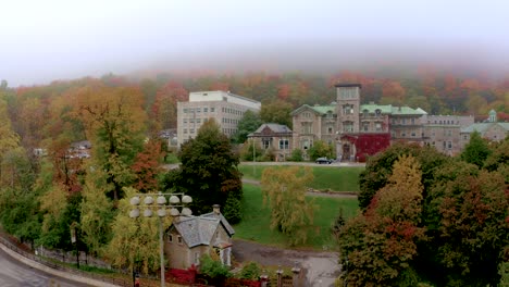 drone moving up on an old building revealing the mount-royal mountain on a misty fall morning