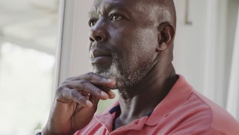 un anciano afroamericano pensativo tocando su barbilla en cámara lenta