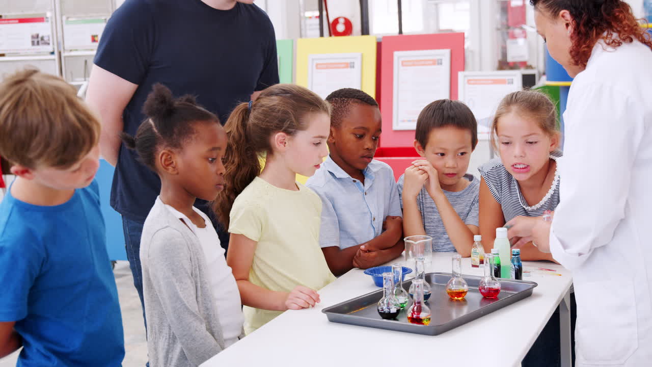niños y el maestro mostrando un experimento en un centro de ciencias