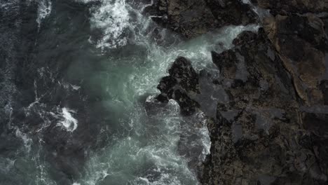 overhead view of a sea waves over rugged shoreline