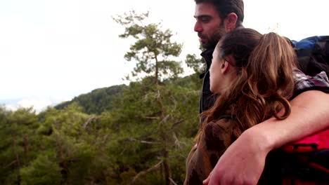 hikers couple on mountain embracing and looking at the view