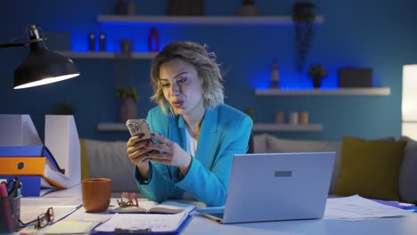 Woman-working-from-home-enjoys-mobile-apps-on-phone.