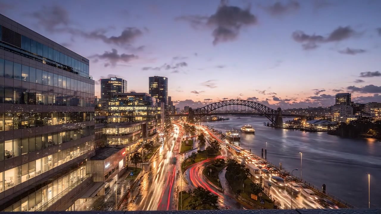 Stunning Urban Landscape at Dusk and Nighttime: A City Skyline with Reflections, Waterway, and Iconic Bridge Illuminated by Night Lights