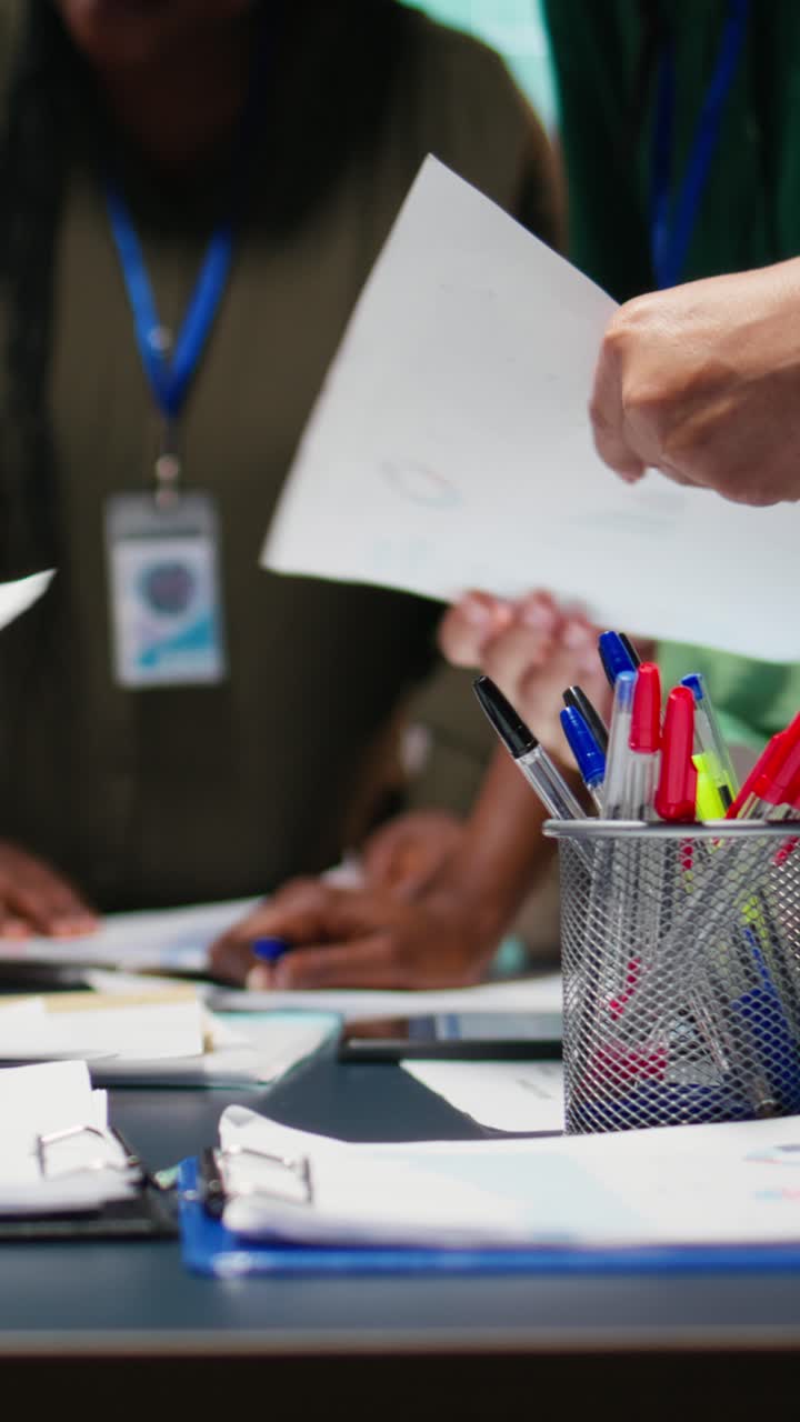 Vertical Video After hours briefing with multiethnic group gathering in a strategy room