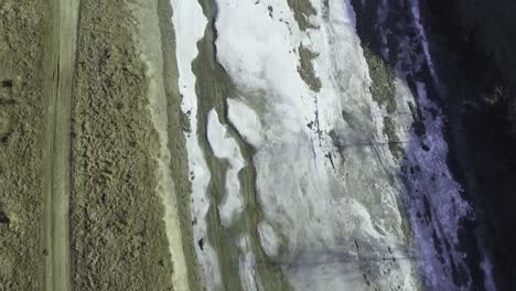 Drone-shot-of-the-forest-and-a-country-icy-river-in-the-late-autumn