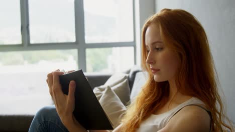 mujer leyendo un libro en la sala de estar 4k