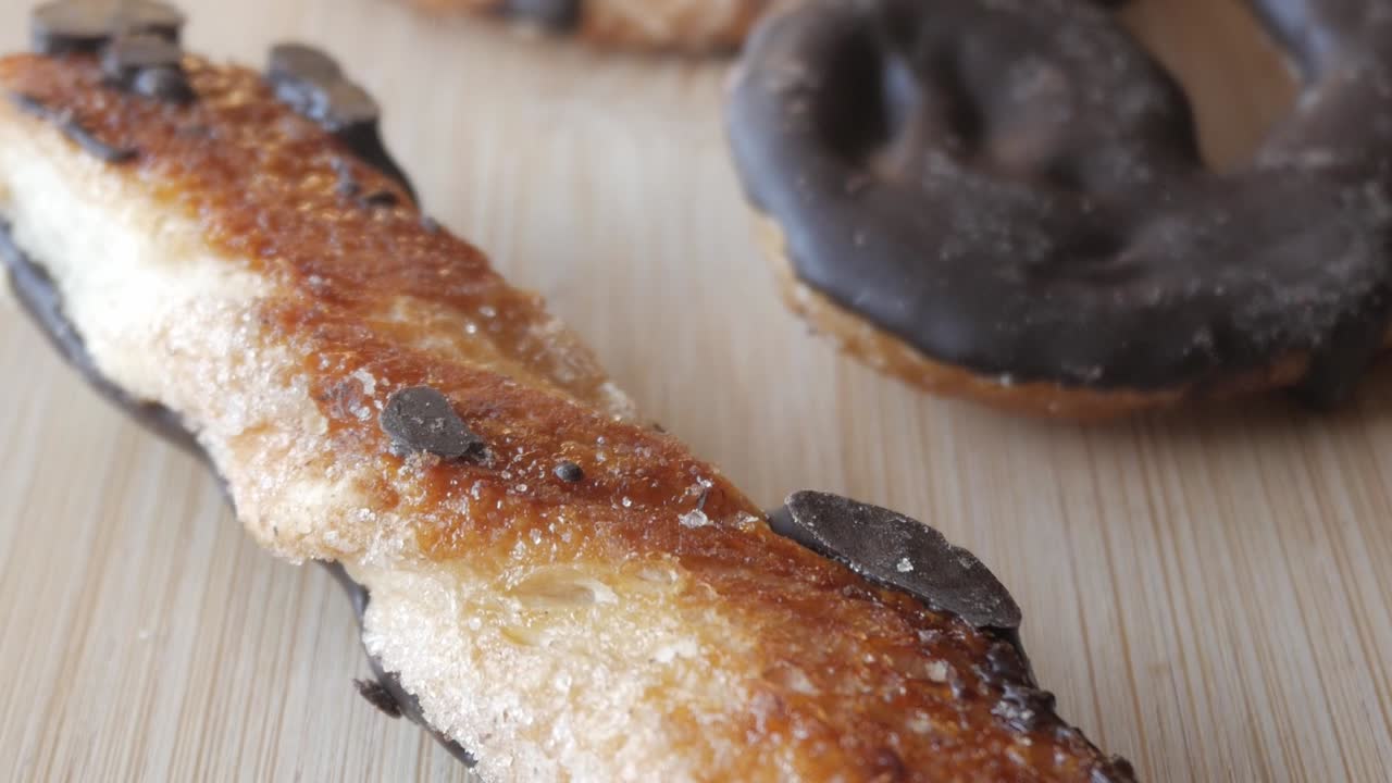 Golden palmeras pastry with chocolate coating, sprinkled with sugar and flakes