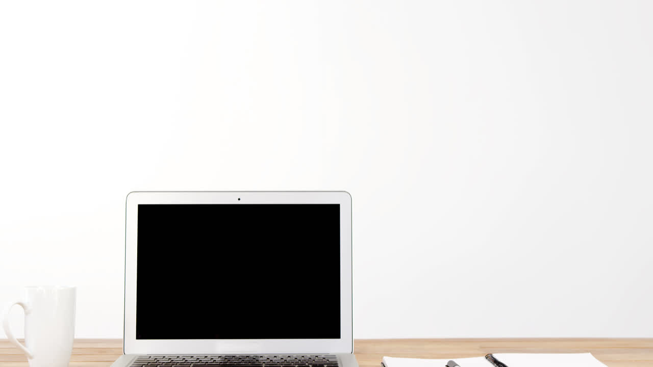 portátil con diario y bolígrafo en la mesa