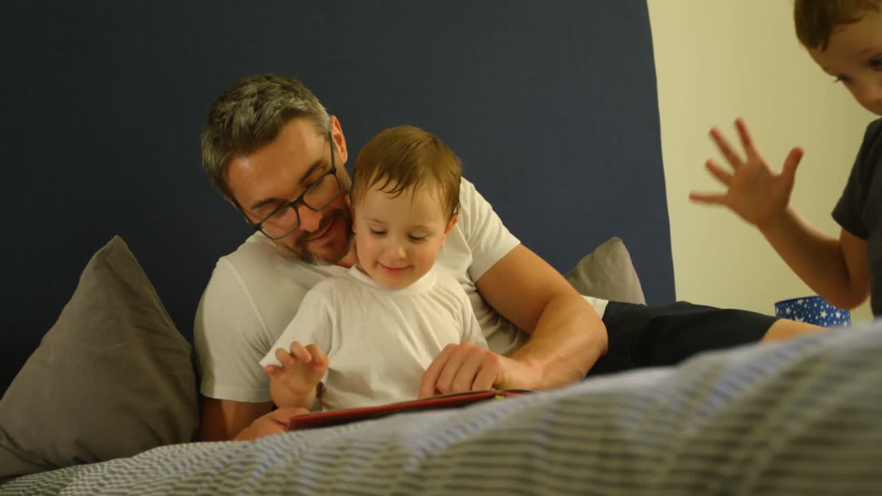 padre e hijo leyendo un libro en la cama 4k