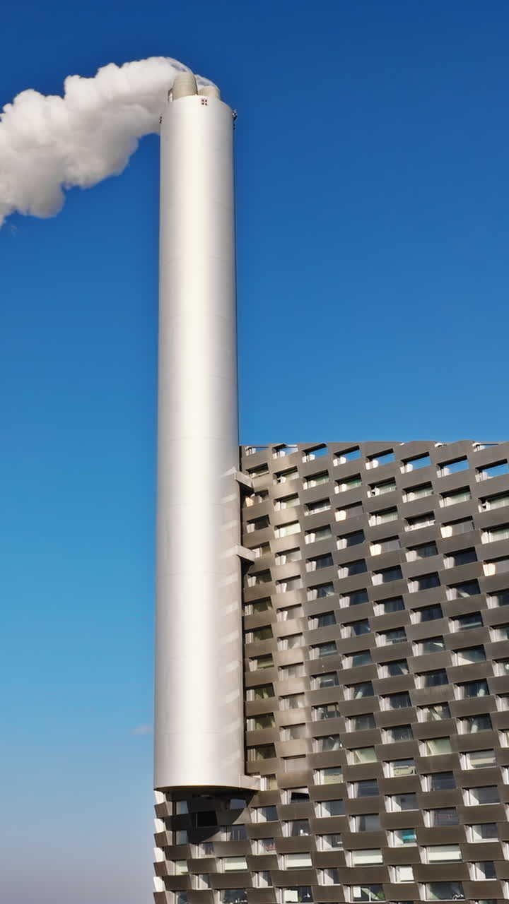 Aerial drone view of CopenHill artificial ski slope on the roof of an energy plant. Vertical