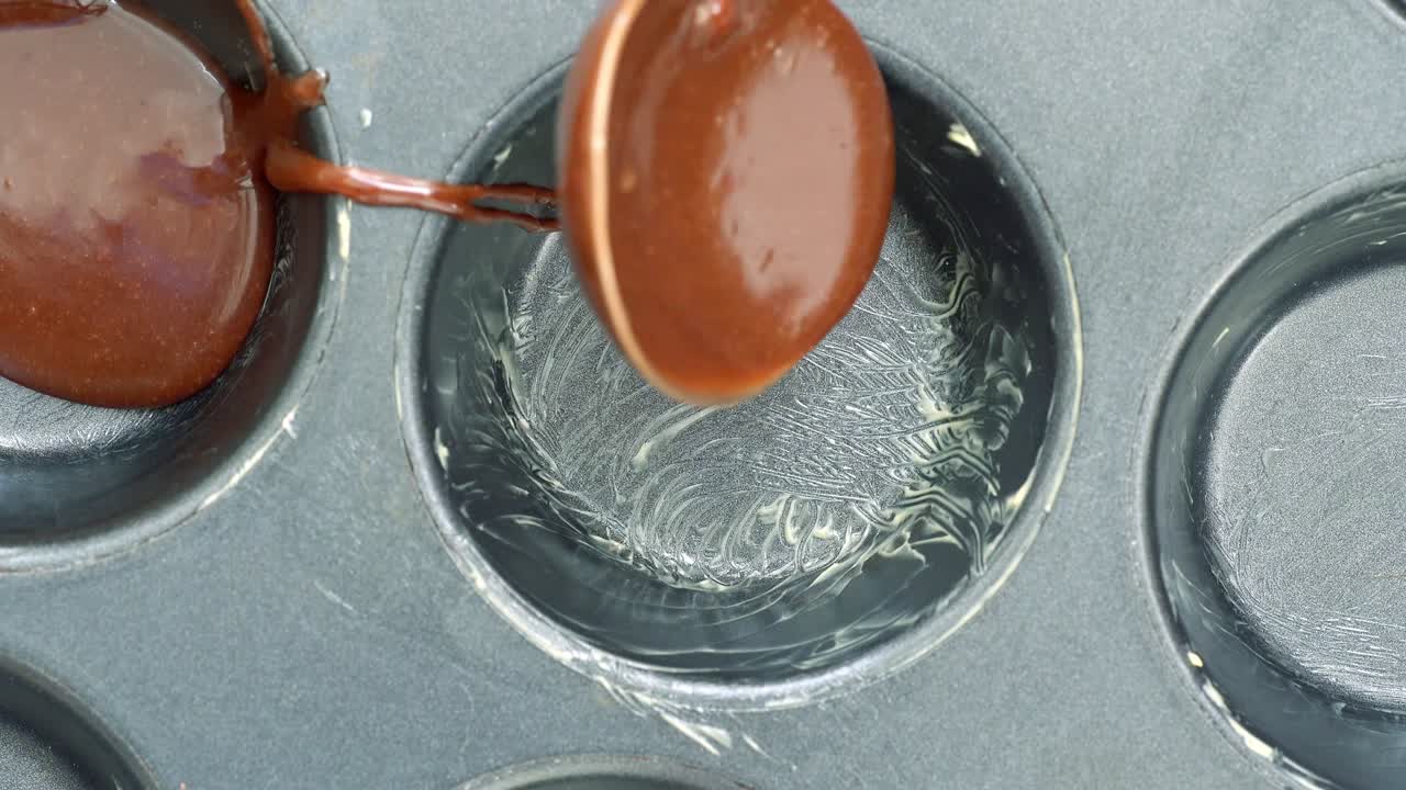 alguien vertiendo masa de chocolate en el molde