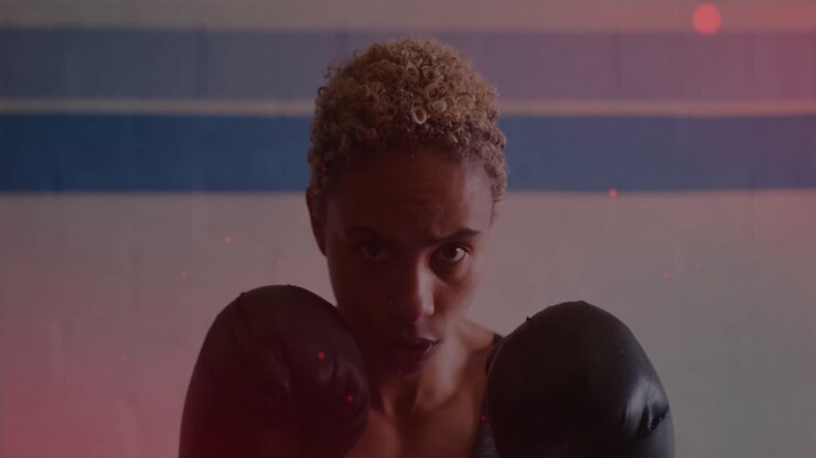 Boxer shifting guard, jabbing lens with glove, sports training, red specks rising over blue stripes